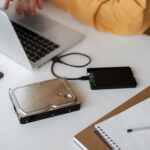 Moderni darbo vieta su SSD ir HDD diskais, demonstruojanti greitą duomenų perdavimą.